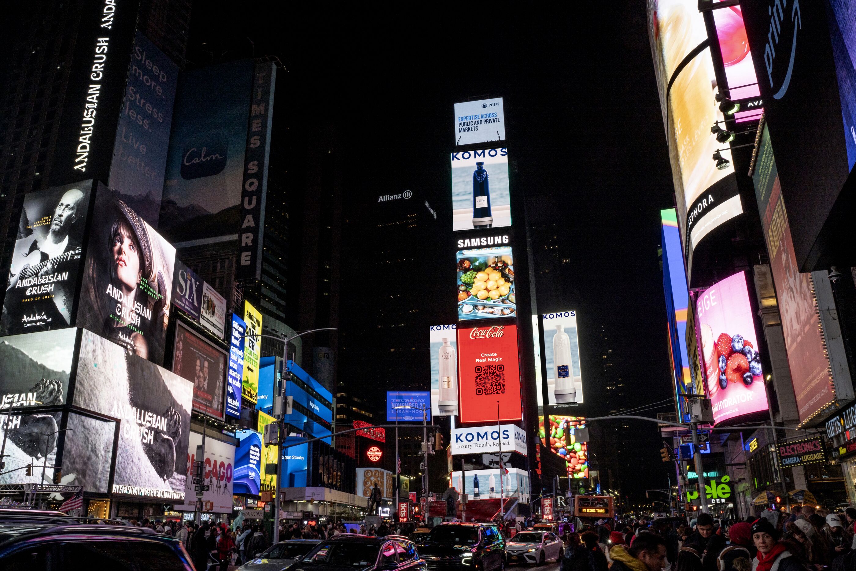 Komos campaign on screens in Times Square at night